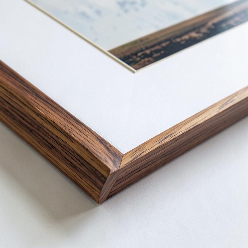 Close detail of a walnut frame corner and snow white mat